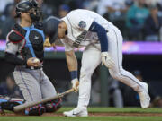 Seattle Mariners' Jarred Kelenic cracks his bat as he reacts to striking out against the Miami Marlins during the seventh inning of a baseball game Wednesday, June 14, 2023, in Seattle.