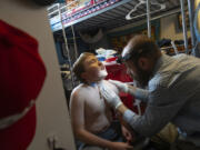 Nathan Hill changes the trach tube on his son Brady at their home in Meridian, Idaho, June 19, 2023. Brady survived a rare brain cancer as a baby, but requires round the clock care. Each morning Nate and his wife spend about 3 hours with Brady performing his medical cares and getting him ready for the day. Families of severely disabled children across the country are worried about the future of crucial Medicaid payments they started receiving to provide care during the COVID-19 pandemic.