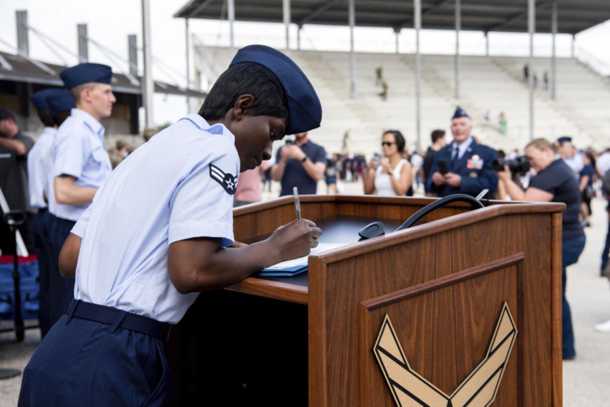 Airman 1st Class D'elbrah Assamoi, from Cote D'Ivoire, signs her U.S. certificate of citizenship after the Basic Military Training Coin Ceremony at Joint Base San Antonio-Lackland, in San Antonio, April 26, 2023. The U.S. military has struggled to overcome recruiting shortfalls and as a way to address that problem, it's stepping up efforts to sign up immigrants, offering a fast track to American citizenship to those who join the armed services. The Army and the Air Force have bolstered their marketing to entice legal residents to enlist. (Vanessa R. Adame/U.S.