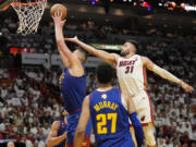 Denver Nuggets center Nikola Jokic (15) drives to the basket as Miami Heat guard Max Strus (31) attempts to defend during the first half of Game 3 of the NBA Finals basketball game, Wednesday, June 7, 2023, in Miami.