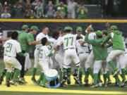 Oregon players celebrate after their win over Oral Roberts in an NCAA college baseball tournament super regional game Friday, June 9, 2023, in Eugene, Ore.