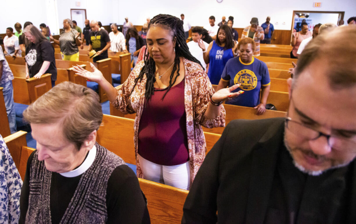 Attendees pray during a press conference with attorney Ben Crump regarding the shooting of Ajike Owens,, Wednesday afternoon, June 7, 2023, at the New St. John Missionary Baptist Church in Ocala, Fla. Susan Louise Lorincz, 58, who is accused of fatally shooting Owens last week in the violent culmination of what the sheriff described as a 2 and a half year feud was arrested Tuesday, June 6, the Marion County Sheriff's Office said.