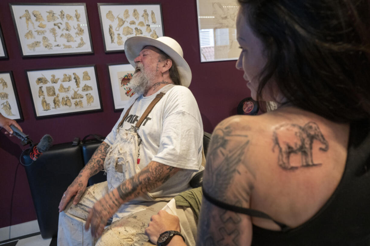 Henk Schiffmacher's talks Monday after his needle whirred as he tattooed the lines of an elephant on Lilian Rachmaran's back in Amsterdam.