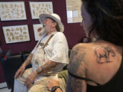 Henk Schiffmacher's talks Monday after his needle whirred as he tattooed the lines of an elephant on Lilian Rachmaran's back in Amsterdam.