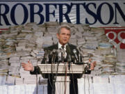 FILE - Pat Robertson, stands in front of stacks of signatures as he announced his intentions to collect a total of 7 million signatures during a news conference on Sept. 15, 1987 in Chesapeake, Va. Robertson, a religious broadcaster who turned a tiny Virginia station into the global Christian Broadcasting Network, tried a run for president and helped make religion central to Republican Party politics in America through his Christian Coalition, has died. He was 93. Robertson's death Thursday, June 8, 2023 was announced by his broadcasting network.