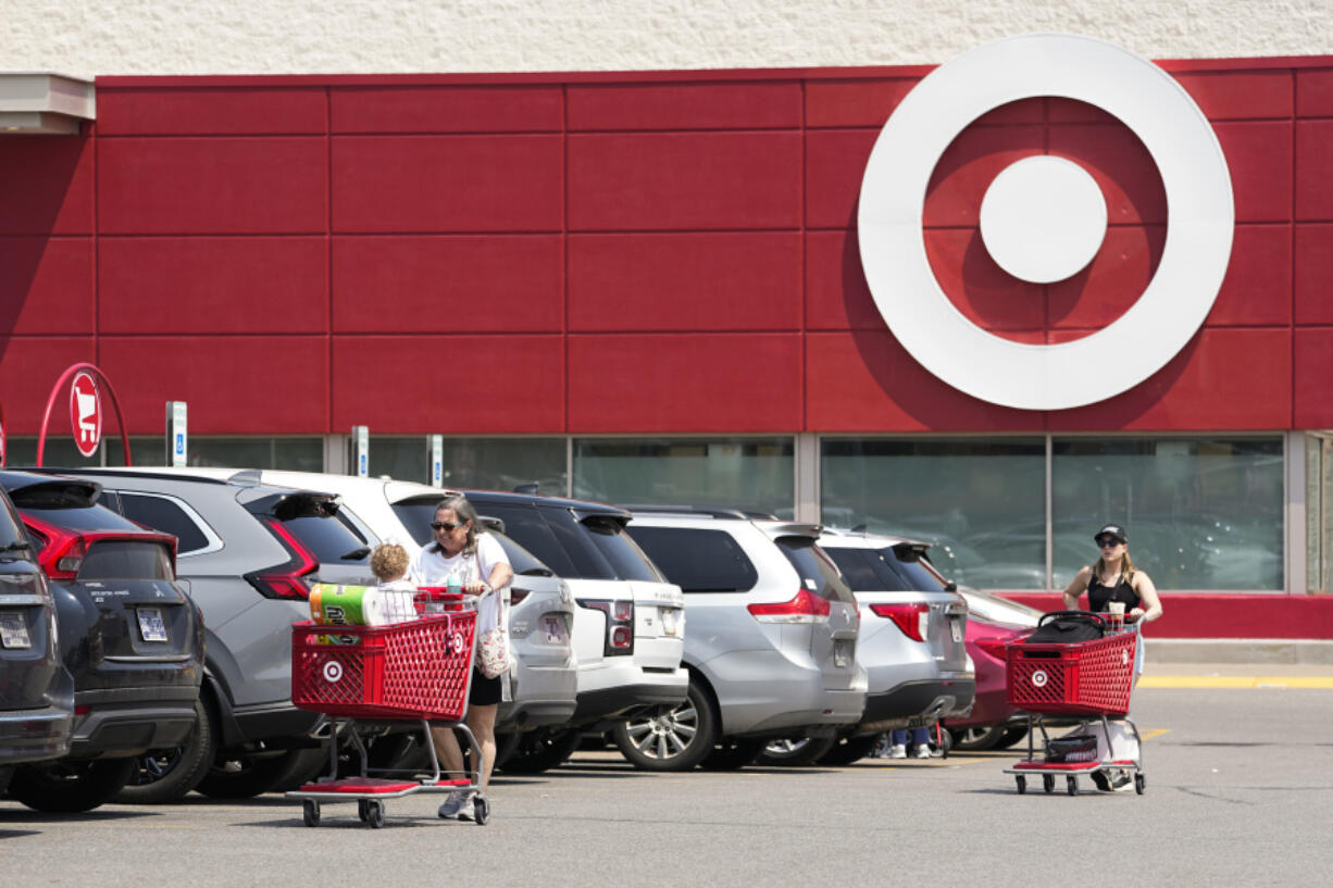 FILE - Customers make their way through the parking lot of a Target store Wednesday, May 24, 2023, in Nashville, Tenn.  Target, Macy's and Dollar General are warning investors their sales will suffer during the remainder of 2023 as consumers shift spending to essentials.