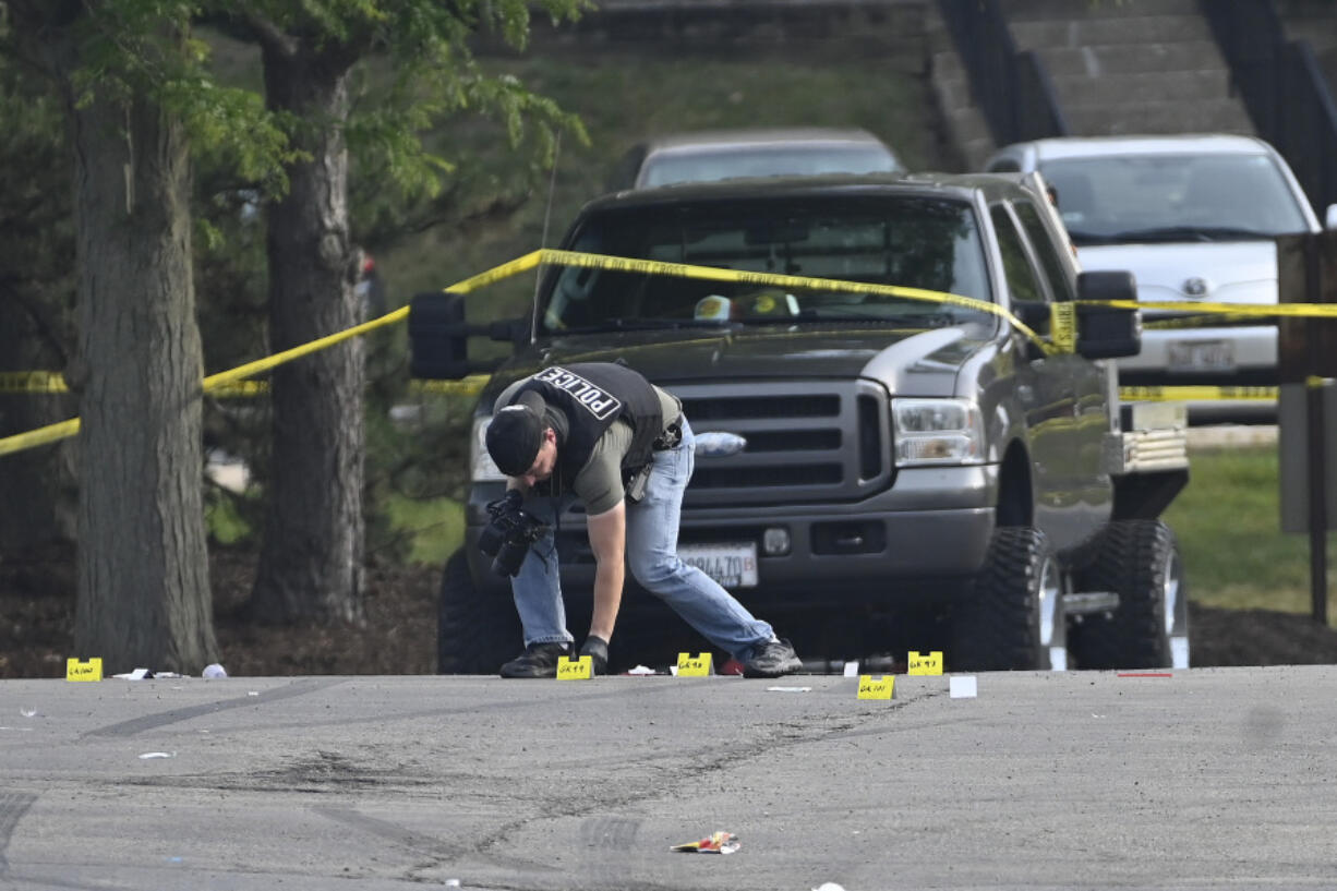 A police officer works the scene of an overnight mass shooting at a strip mall in Willowbrook, Ill., Sunday, June 18, 2023.