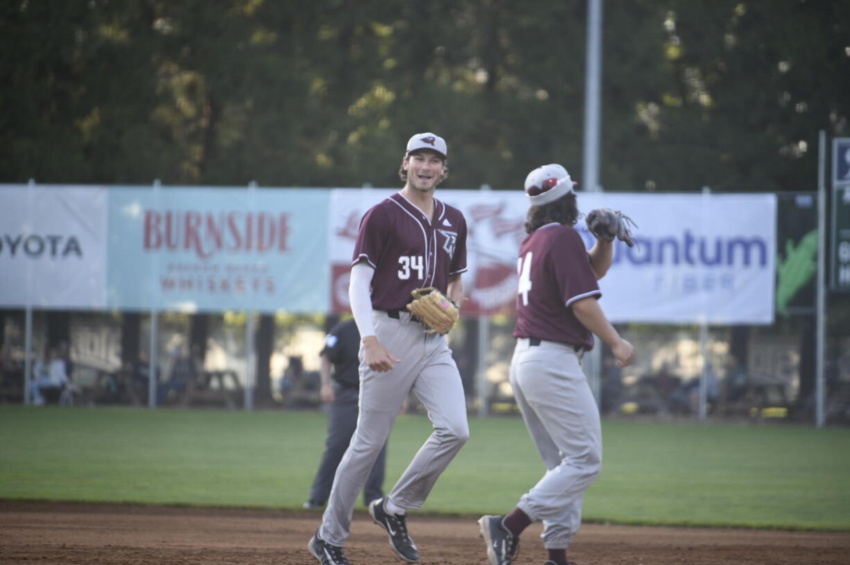 Ridgefield Raptors outfielder Tristan Gomes, left, is greeted by outfielder Jake Tsukada after Gomes made a leaping catch in left field to end the third inning against the Portland Pickles at Walker Stadium in Portland on Wednesday, June 14, 2023.