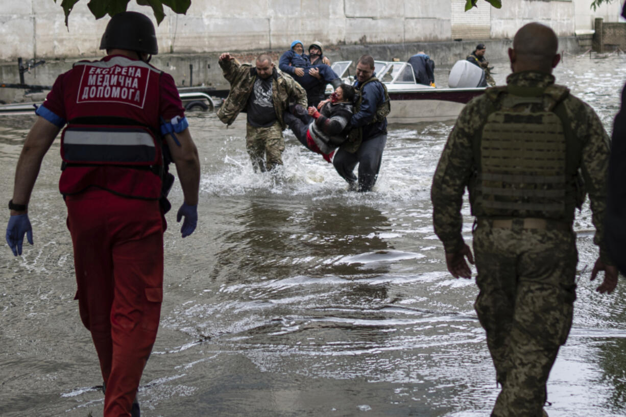 Emergency teams help rush to safety injured civilian evacuees who had came under fire from Russian forces while trying to flee by boat from the Russian-occupied east bank of a flooded Dnieper River to Ukrainian-held Kherson, on the western bank in Kherson, Ukraine on Sunday, June 11, 2023.