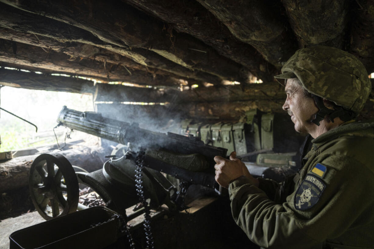 FILE - A Ukrainian serviceman of 28th brigade shoots a Maxim gun towards Russian positions at the frontline in Donetsk region, Ukraine, Wednesday, June 21, 2023. Ukraine's June 10 recapture of the small village of Neskuchne in the eastern Donetsk region encapsulates the progress of its much-anticipated counteroffensive: small platoon-sized operations banking on the element of surprise and, when successful, notching incremental territorial gains.