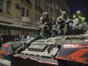 FILE - Membes of the Wagner Group military company sit atop of a tank on a street in Rostov-on-Don, Russia, Saturday, June 24, 2023, prior to leaving an area at the headquarters of the Southern Military District.