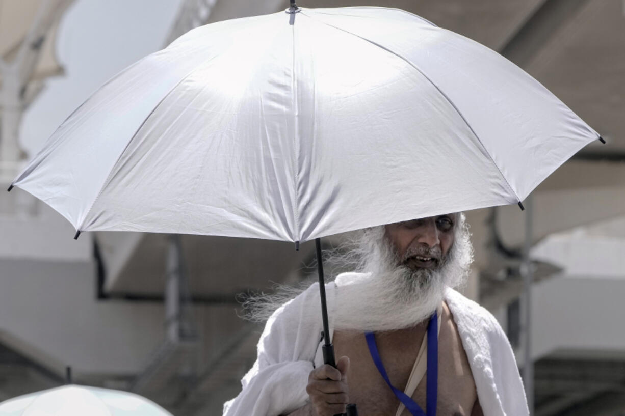 An Indian pilgrim holds his umbrella at the Mina tent camp, in Mecca, Saudi Arabia, during the annual hajj pilgrimage, Monday, June 26, 2023. Muslim pilgrims are converging on Saudi Arabia's holy city of Mecca for the largest hajj since the coronavirus pandemic severely curtailed access to one of Islam's five pillars.