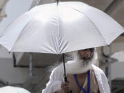 An Indian pilgrim holds his umbrella at the Mina tent camp, in Mecca, Saudi Arabia, during the annual hajj pilgrimage, Monday, June 26, 2023. Muslim pilgrims are converging on Saudi Arabia's holy city of Mecca for the largest hajj since the coronavirus pandemic severely curtailed access to one of Islam's five pillars.