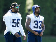 Seattle Seahawks linebacker Jordyn Brooks (56) and safety Jamal Adams (33) talk during NFL football practice, Tuesday, June 6, 2023, at the team's facilities in Renton, Wash.