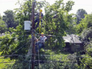 Workers on a utility pole tend to the power lines after the weekend storms left many in the city without power Thursday, June 22, 2023, in Tulsa, Okla.