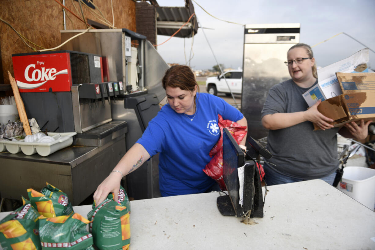 Jaci Deweese, left, and Ashley Krider pick up coffee to take to the local nursing home after a tornado, Thursday, June 22, 2023, in Matador, Texas. A line of severe storms produced what a meteorologist calls a rare combination of multiple tornadoes, hurricane-force winds and softball-sized hail in west Texas, killing at least four people and causing significant damage around the town of Matador, a meteorologist said Thursday.