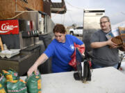 Jaci Deweese, left, and Ashley Krider pick up coffee to take to the local nursing home after a tornado, Thursday, June 22, 2023, in Matador, Texas. A line of severe storms produced what a meteorologist calls a rare combination of multiple tornadoes, hurricane-force winds and softball-sized hail in west Texas, killing at least four people and causing significant damage around the town of Matador, a meteorologist said Thursday.