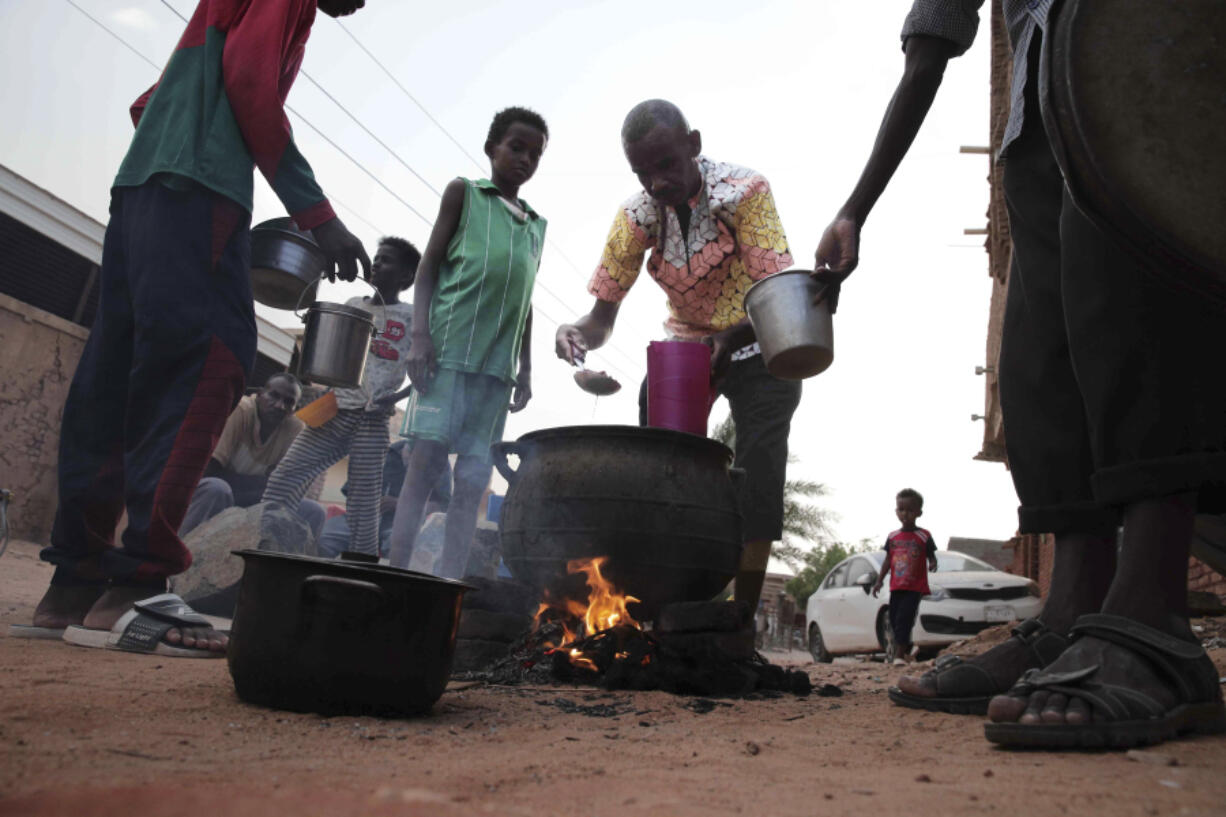 FILE - People prepare food in a Khrtoum neighborhood on June 16, 2023. Sudan's warring parties began a cease-fire Sunday morning, June 18, 2023, after two months of fighting pushed the African nation into chaos.