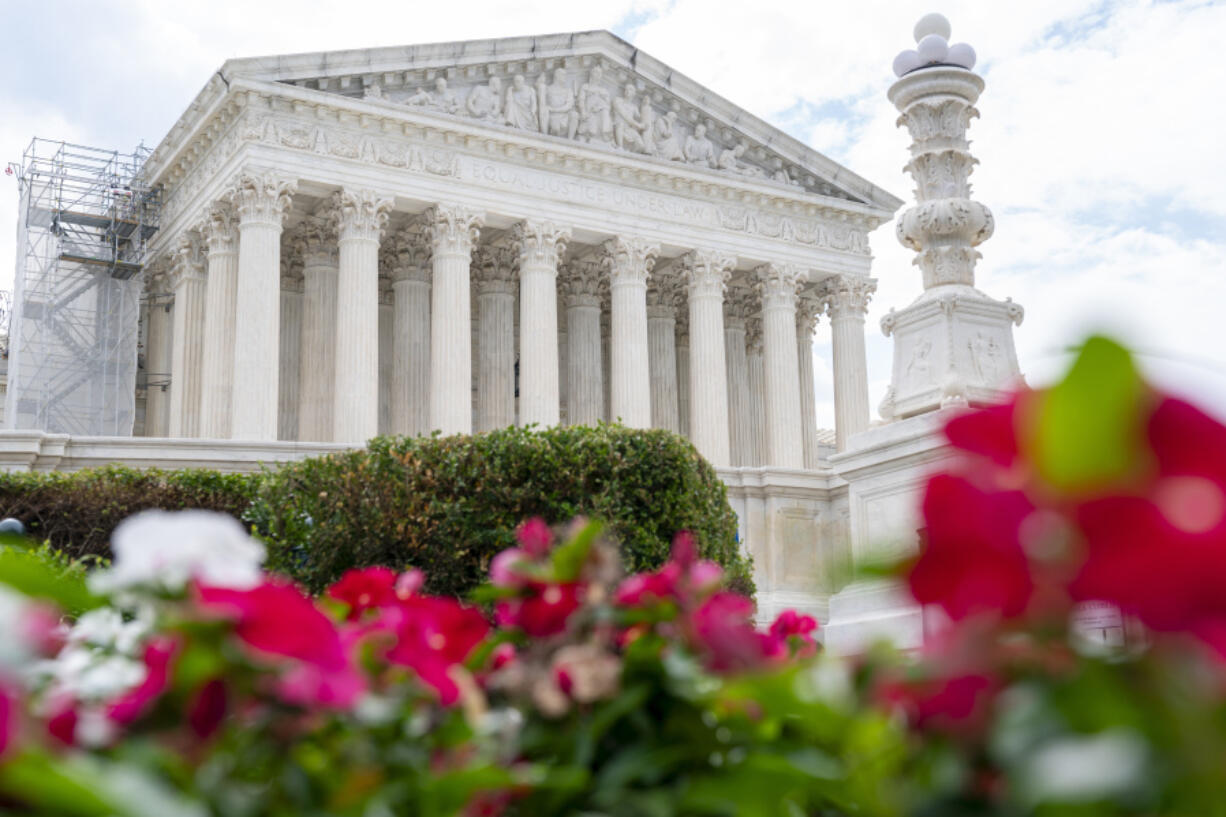 The Supreme Court is seen behind flowers, Tuesday, June 27, 2023, in Washington, as decisions are expected.