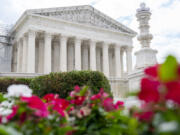 The Supreme Court is seen behind flowers, Tuesday, June 27, 2023, in Washington, as decisions are expected.