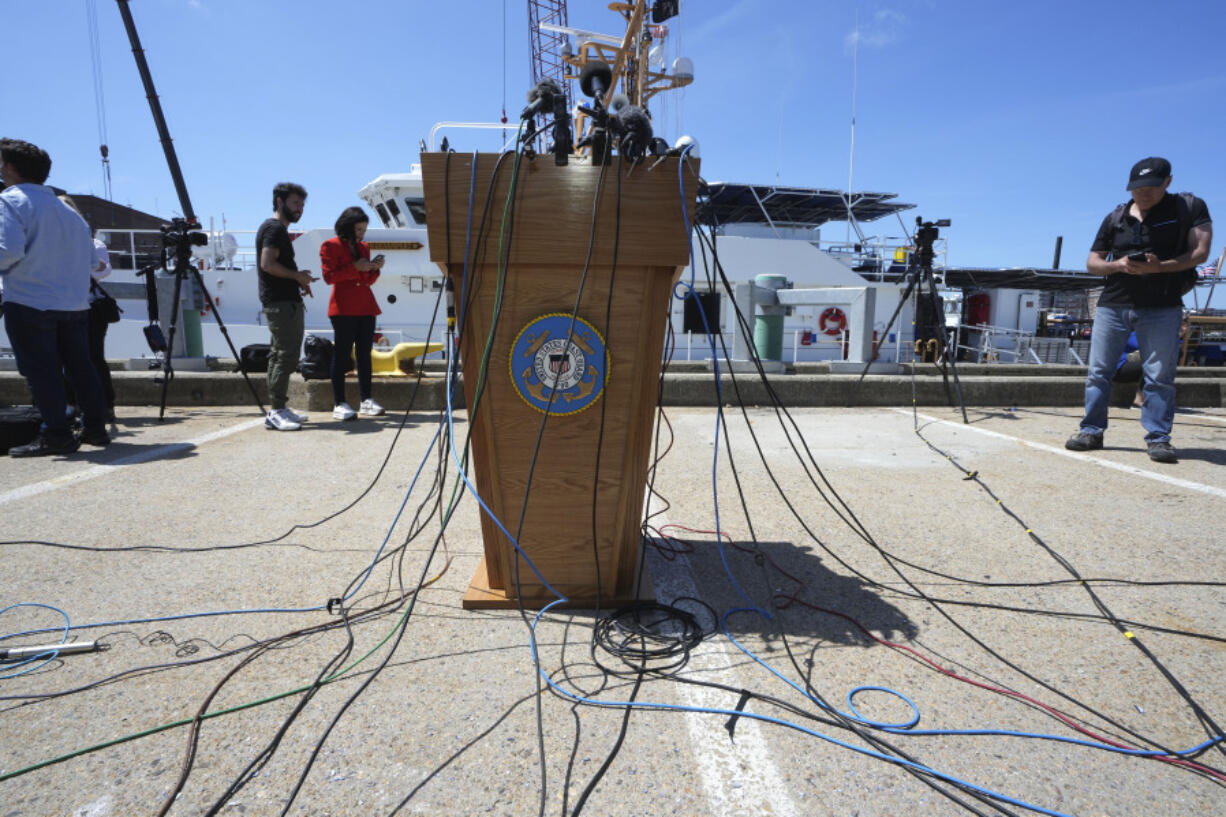 A podium with a U.S. Coast Guard emblem, center, is surrounded with wires attached to microphones moments before a news conference with U.S. Coast Guard Rear Adm. John Mauger, commander of the First Coast Guard District, not shown, Thursday, June 22, 2023, at Coast Guard Base Boston, in Boston. The missing submersible Titan imploded near the wreckage of the Titanic, killing all five people on board, according to the U.S. Coast Guard.