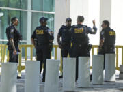 Federal Protective Service Police talk outside the Wilkie D. Ferguson Jr. U.S. Courthouse, Monday, June 12, 2023, in Miami. Former President Donald Trump is set to appear at the federal court Tuesday, on dozens of felony charges accusing him of illegally hoarding classified information.