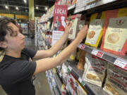 Caroline Cotto, Co-Founder, Renewal Mill, adjusts her company's upcycled food products on a shelf inside a Whole Foods store in Oakland, Calif., Wednesday, June 7, 2023. World Upcycling Day is June 24, celebrating the repurposing of old products into something new. This year, the movement is focusing on upcycling food, like misshapen produce or offcuts of meat, as a way to prevent food waste.