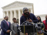 FILE - Evan Milligan, center, plaintiff in Merrill v. Milligan, an Alabama redistricting case that could have far-reaching effects on minority voting power across the United States, speaks with reporters following oral arguments at the Supreme Court in Washington, Oct. 4, 2022. Standing behind Milligan are Milligan's counsel Deuel Ross, from left, Letetia Jackson, Rep. Terri Sewell, D-Ala., and Janai Nelson, President and Director-Counsel of the NAACP Legal Defense Fund. A U.S. Supreme Court decision a decade ago that tossed out the heart of the Voting Rights Act continues to reverberate across the country. Republican-led states continue to pass voting restrictions that, in several cases, would have been subject to federal review had the court left the provision intact.