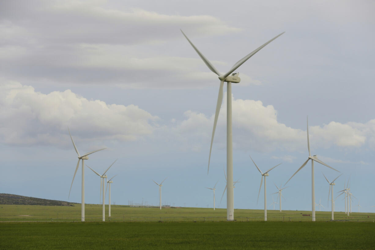 FILE - Wind turbines stand at a wind farm along the Montana-Wyoming state line on June 13, 2022. Wyoming and federal officials will formally kick off construction Tuesday, June 20, 2023, of a massive transmission line project to export wind power from Wyoming to southern California. But despite extensive wildlife studies, design tweaks and clearing of lengthy federal environmental reviews, the projects are now being built amid a more tepid attitude about wind power in Wyoming than when they were first proposed more than 15 years ago. (AP Photo/Emma H.