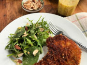 Fried panko-breaded pork chops are paired with an arugula salad dressed in a bright and zesty whole-lemon vinaigrette.