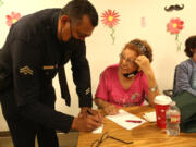 Los Angeles Police Department Det. Albert Smith leaves his card with Marta Barillas, who was robbed recently, after a presentation about financial scams and physical abuse against seniors June 15 at St. Barnabas Senior Services in Los Angeles.