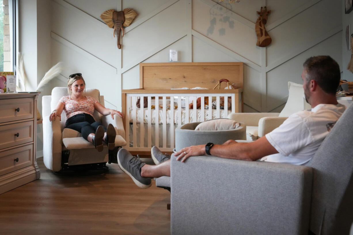 Andrew and Katie Beiswenger, who are 20 weeks along with their first daughter, test out rocking chairs at Baby Grand in St. Louis Park, Minnesota, on June 28, 2023. (Shari L.