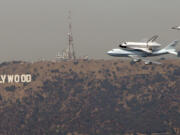 The space shuttle Endeavour passes the Hollywood sign before landing at LAX on Sept. 21, 2012.