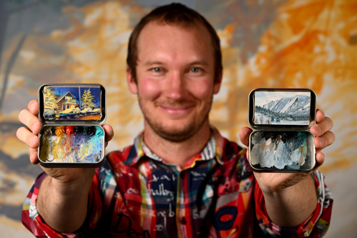 Painter Remington Robinson shows off two of his painted Altoids tin boxes at his art studio in Boulder, Colo. (Helen H.