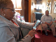 Samantha Hart, daughter of Henry Hart, who has dementia, looks at a photo of the release of her father from police custody while her mother, Rosalind Hart, looks on at the Hart home. The family filed a complaint with Baltimore County after his health declined when he was taken to jail.