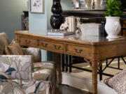 A desk steals the spotlight with its exquisite chippendale side panel, accentuated by acrylic pulls with brass accents.