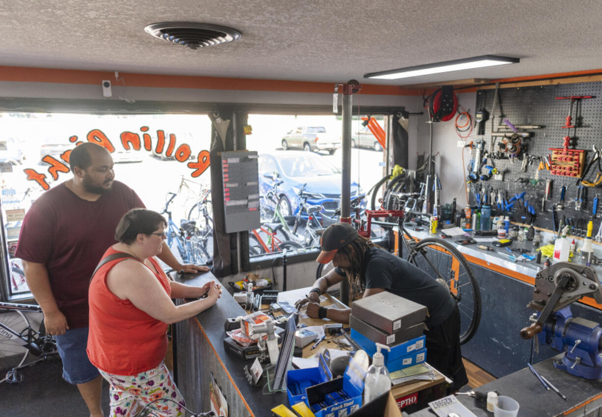 Small business owner Edward Eley, right, gets an estimate for customers Robert Cherry III, left, and Krystal Rodda, both of Vancouver, at Rollin Right Bike Repair and Service. Clark County was recently ranked as one of the best counties for small businesses in the state.