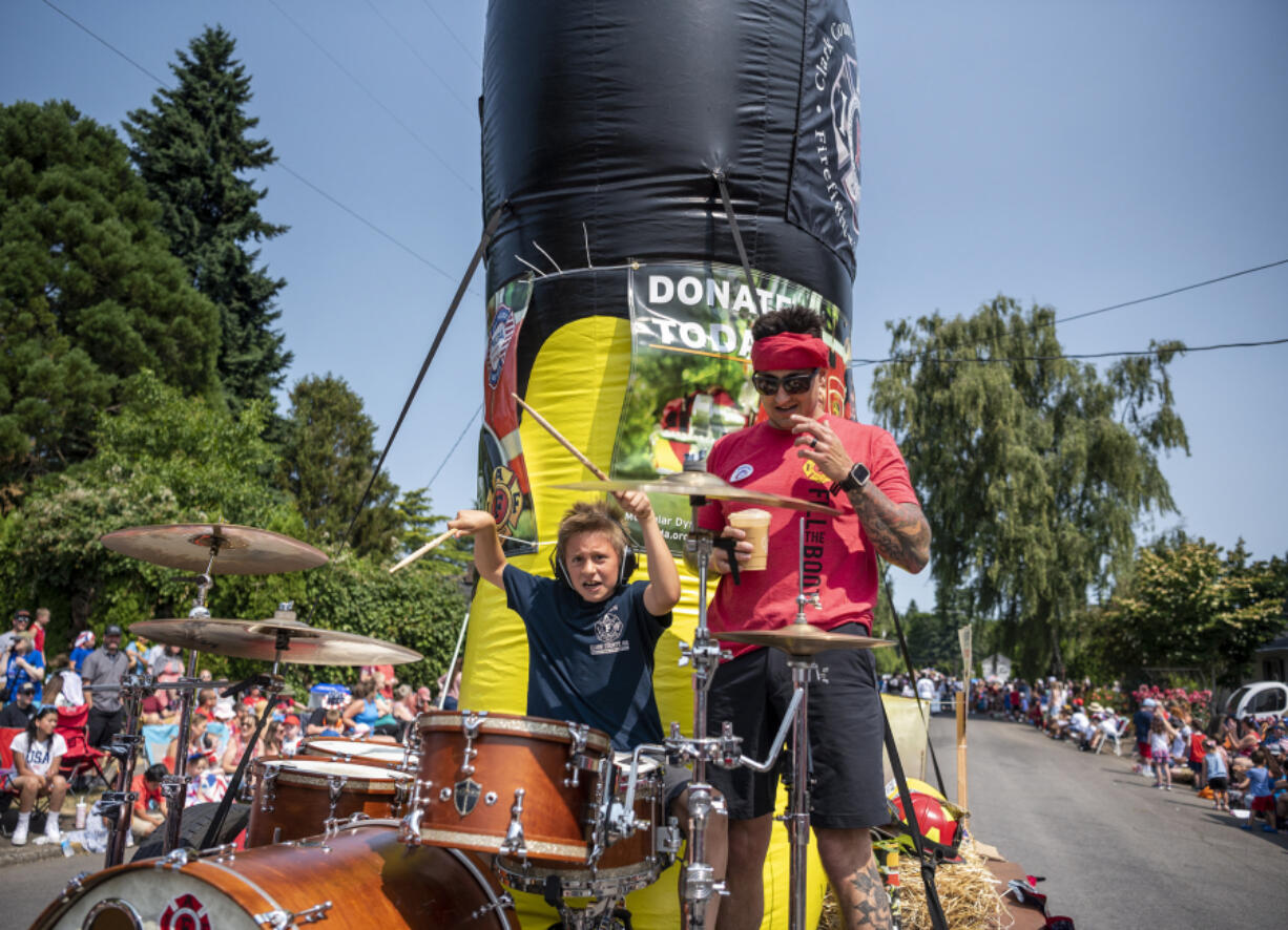 A drummer performs on the Clark County Firefighters 'Fill The Boot' float entered in Ridgefield's Fourth of July parade.