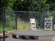 Signs, chains, fencing and a locked gate block access to a section of the Gee Creek trail in Ridgefield. According to city officials, the trail was closed in November after heavy rains eroded slopes along the creek and downed some trees.