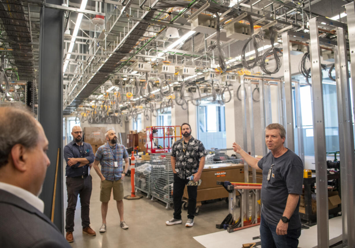 Bonneville Power Administration's Steven Laslo, right, talks about the building's "fishbowl," an insider term describing a glass-enclosed testing area packed with equipment. BPA commemorated its new Technical Services Building at its Ross Complex in Vancouver.