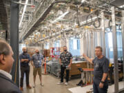 Bonneville Power Administration's Steven Laslo, right, talks about the building's "fishbowl," an insider term describing a glass-enclosed testing area packed with equipment. BPA commemorated its new Technical Services Building at its Ross Complex in Vancouver.