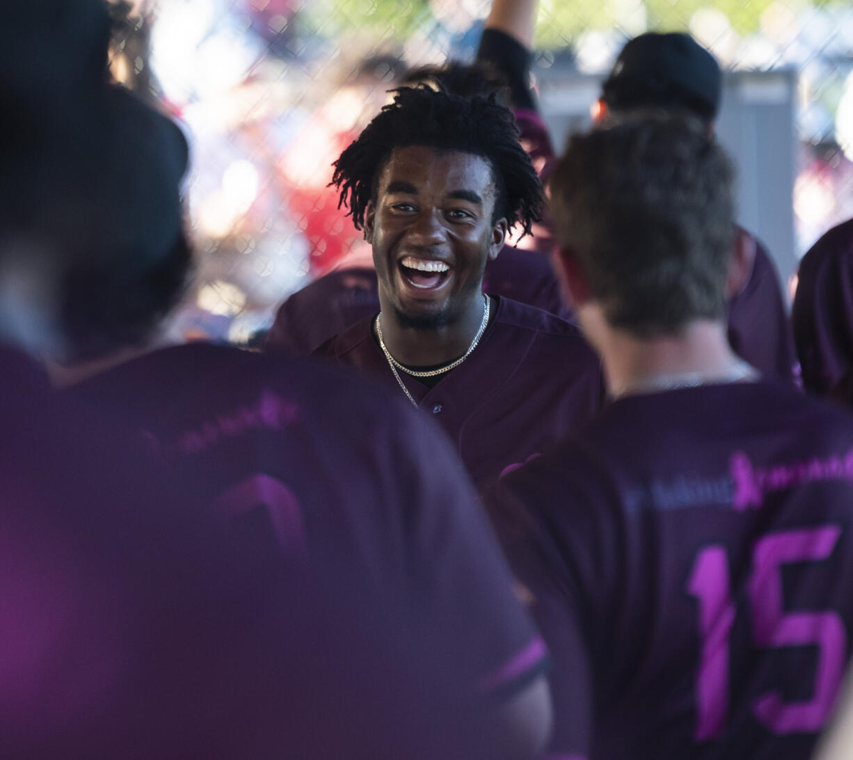 Raptors player Reiss Calvin smiles in the dugout after scoring a run Friday, July 14, 2023, during the Raptors’ game against Yakima Valley at the Ridgefield Outdoor Recreation Complex.