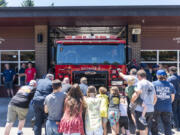 Community members and District 6's fire crew push a new fire engine into Station 62.