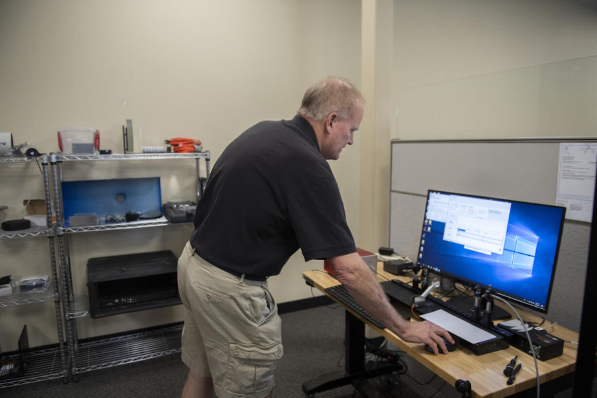 Don Gamiles, president of Argos Scientific, looks over an open path UV air monitoring system in Camas. Argos Scientific's equipment monitors air quality throughout the world.