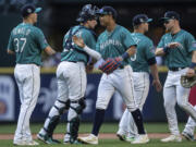 From left to right, Seattle Mariners relief pitcher Paul Sewald, catcher Cal Raleigh, centerfielder Julio Rodriguez, first baseman Ty France and left fielder Jarred Kelenic celebrate after a baseball game against the Tampa Bay Rays, Saturday, July 1, 2023, in Seattle.