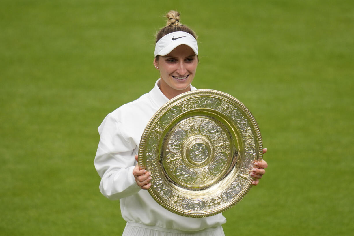 Czech Republic's Marketa Vondrousova celebrates with the trophy after beating Tunisia's Ons Jabeur to win the final of the women's singles on day thirteen of the Wimbledon tennis championships in London, Saturday, July 15, 2023.