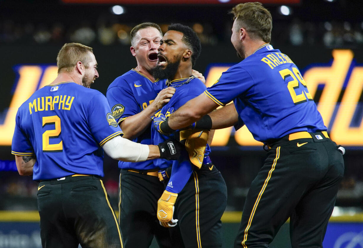 Seattle Mariners' Teoscar Hernandez, third from left, is mobbed by teammates Tom Murphy (2), Paul Sewald, second from left, and Cal Raleigh (29) after hitting a walk-off single for a 3-2 win over the Toronto Blue Jays in a baseball game, Friday, July 21, 2023, in Seattle.