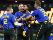 Seattle Mariners' Teoscar Hernandez, third from left, is mobbed by teammates Tom Murphy (2), Paul Sewald, second from left, and Cal Raleigh (29) after hitting a walk-off single for a 3-2 win over the Toronto Blue Jays in a baseball game, Friday, July 21, 2023, in Seattle.