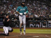 Seattle Mariners' J.P. Crawford, right, reacts after striking out against the Arizona Diamondbacks in the seventh inning during a baseball game, Saturday, July 29, 2023, in Phoenix.