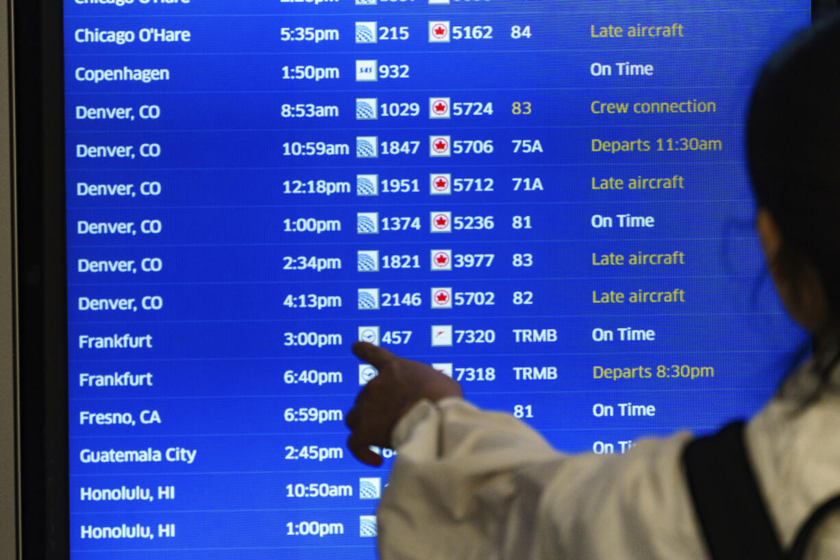 A traveler checks the departures flight board June 28 at the United Airlines terminal at Los Angeles International airport in Los Angeles.